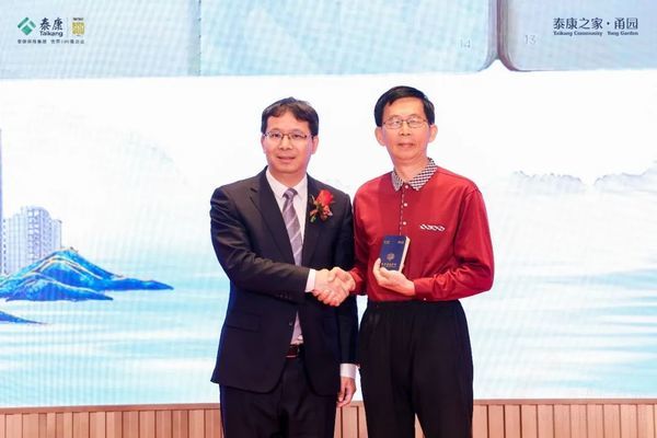 泰康之家助理总裁兼泰康之家首席运营官张惠丰为泰康之家“候鸟旅居达人”朱安人叔叔的泰康居民护照盖章